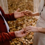 Les mariés se tenant délicatement le bout des doigts.