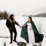 Les époux main dans la main devant le lac gelé.