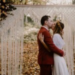 Les mariés s'embrassant dans la forêt.