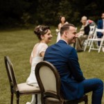 Les mariés souriant en regardant l'officiante de cérémonie.