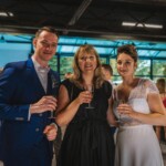 L'officiante et les mariés avec une coupe de champagne à la main.