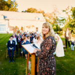 L'officiante de cérémonie, La Semeuse de Bonheur, souriant au photographe avant le début de la cérémonie.