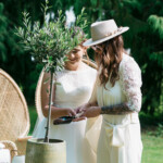 Les mariés mettant une pelletée de terrre au pied de l'olivier lors du rituel de l'arbre à voeux.