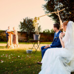 Plan de côté des mariés regardant un témoin arrivant pour lire un disours en leur honneur.