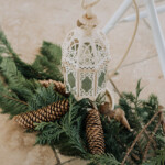 Détail de décoration avec lanterne et pommes de pin.